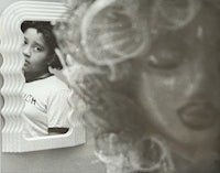 a black and white photo of a woman in front of a mirror