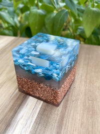 a blue glass cube sitting on top of a wooden table