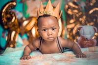 a baby wearing a crown on his head