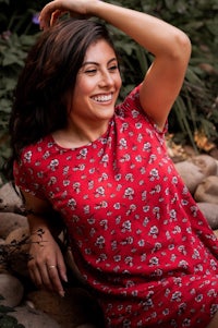 a young woman in a red floral dress posing for a photo