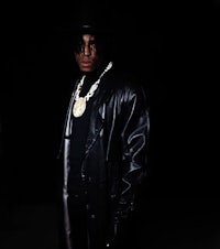 a young man in a black coat and hat