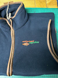 a blue and brown fleece jacket on a cutting board