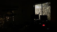 a dark room with a light shining through a window
