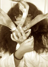 a woman is holding a piece of wood in her hand
