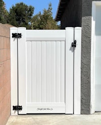 a white wooden gate in front of a house