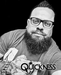 a black and white photo of a man with a beard and tattoos