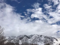 a snow covered mountain with clouds in the sky