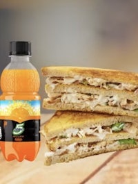 a sandwich next to a bottle of orange juice