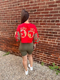 a woman wearing a red crop top and green shorts
