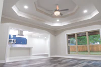 an empty living room with hardwood floors and a ceiling fan