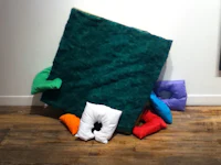 a pile of pillows on a wooden floor