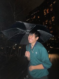 a young man holding a black umbrella