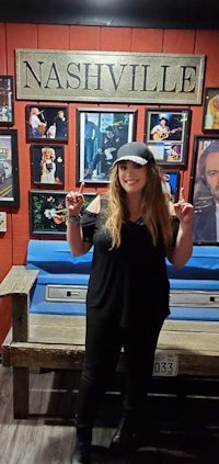 a woman standing in front of a bench in a nashville themed room