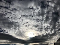 the sun shines through a cloudy sky
