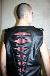 a woman wearing a black leather vest