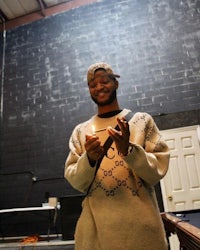 a man holding a candle in front of a pool table