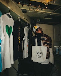 a man holding a t - shirt with a smiley face on it