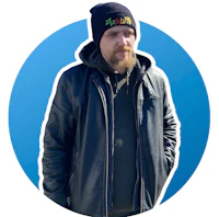a bearded man wearing a black jacket and a beanie
