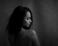 a black and white photo of a woman with tattoos