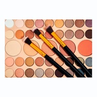 three makeup brushes on top of a colorful background