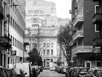 a black and white photo of a street with cars parked in it