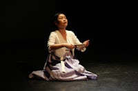 a woman in a white dress sitting on the floor