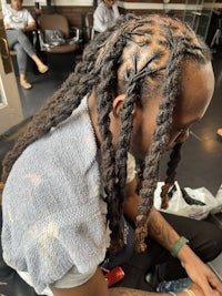 a man with long dreadlocks sitting in a salon