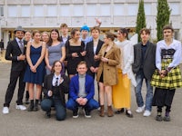 a group of people posing for a photo in front of a building