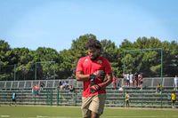 a man in a red shirt is holding a soccer ball