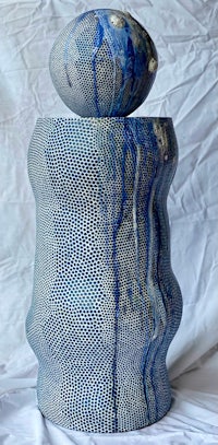 a blue and white vase on a white surface
