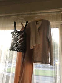 two clothes hanging on a clothesline in front of a window