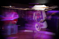 a blurry image of people playing guitar in a dark room