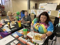 a group of people sitting at a table eating food