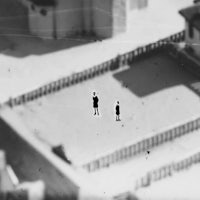 a black and white photo of two people standing on a rooftop