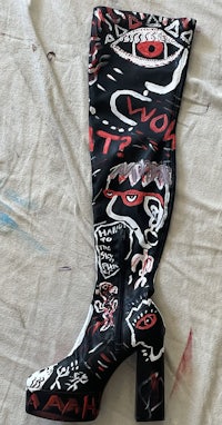 a pair of black and red boots with graffiti on them