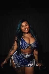 a woman with blue hair and tattoos posing for a photo