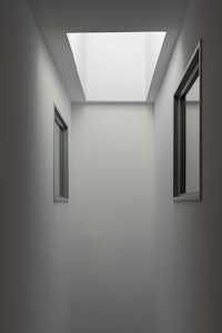 a hallway with two windows and a skylight