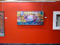 a red wall with paintings hanging on it