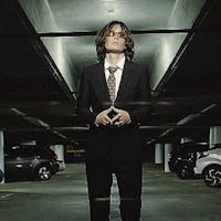 a man in a suit standing in a parking garage