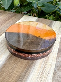 a wooden box with an orange and brown design on it