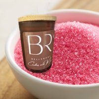 pink sugar in a bowl next to a candle