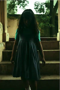 a girl in a blue dress standing on steps