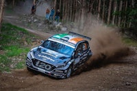 a rally car driving down a dirt road