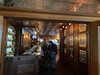 a bar with a wooden door and framed pictures