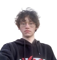 a young man wearing glasses and a hoodie