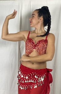 a woman in a red belly dance costume posing