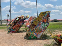 a group of cars with graffiti on them in a field