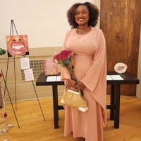 a woman in a pink dress standing in front of art
