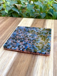 a blue and black coaster on a wooden table