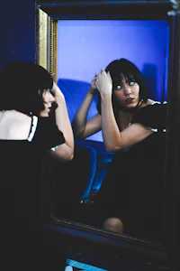 a woman is looking at herself in a mirror